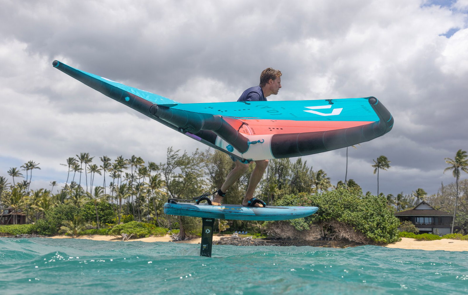 Duotone wingfoil rider with a teal Slick wing and Skybrid foil board in Maui